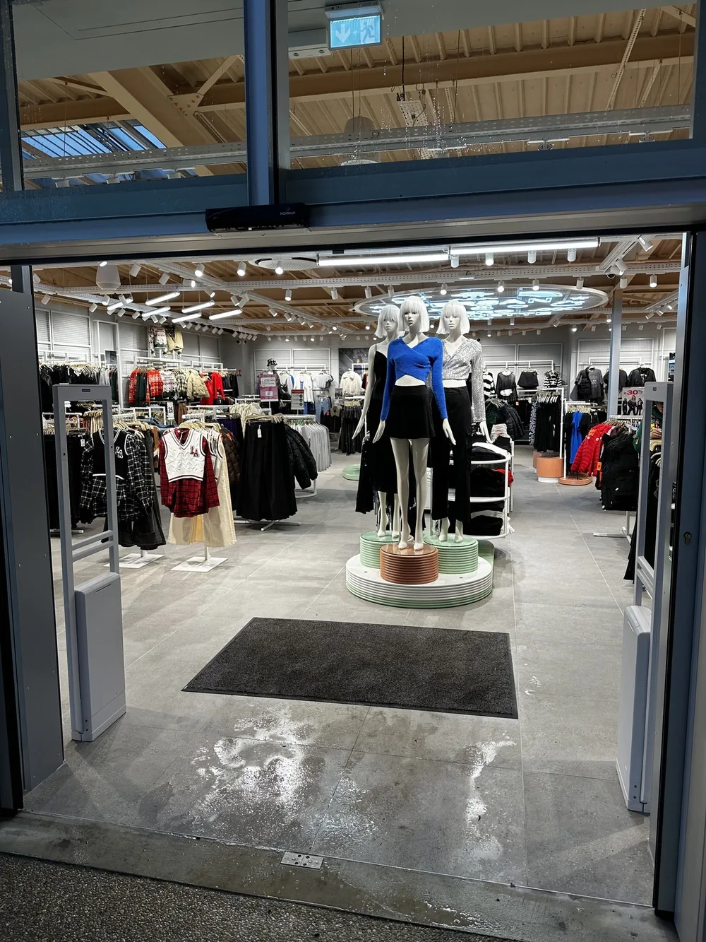 Portiques antivol encadrant l’entrée d’un magasin de prêt-à-porter en centre outlet